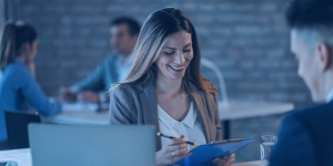 Capa para artigo: investimento conservador. Mulher junto de assessor de investimentos, lendo documentação.